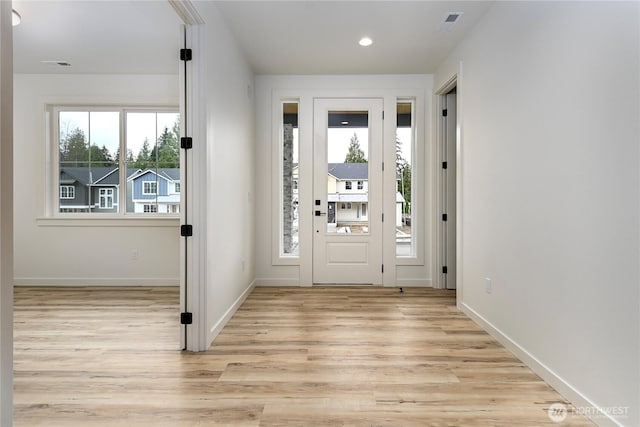 foyer entrance featuring light wood finished floors, recessed lighting, visible vents, and baseboards