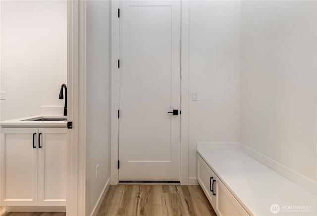 mudroom featuring a sink and light wood finished floors