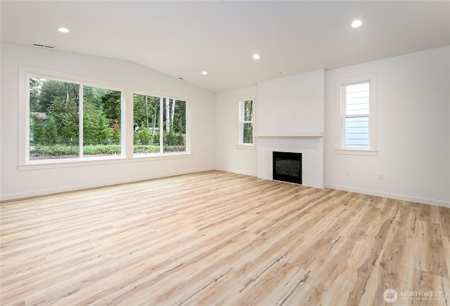 unfurnished living room with lofted ceiling, light wood finished floors, a fireplace, and recessed lighting