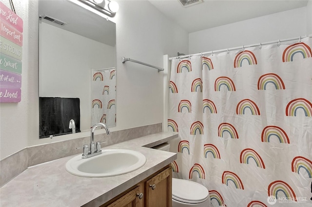 full bathroom featuring toilet, visible vents, a shower with shower curtain, and vanity