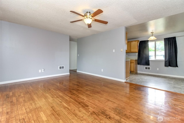 17123 6th Avenue Ct E, Spanaway, WA 98387 - unfurnished living room featuring a ceiling fan, wood-type flooring, a textured ceiling, and baseboards