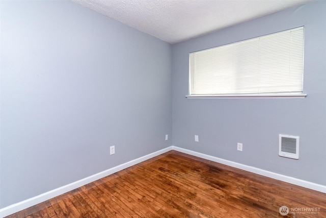 17123 6th Avenue Ct E, Spanaway, WA 98387 - empty room with wood finished floors, baseboards, a textured ceiling, and heating unit