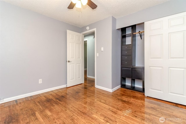 17123 6th Avenue Ct E, Spanaway, WA 98387 - unfurnished bedroom featuring baseboards, wood finished floors, a textured ceiling, ceiling fan, and a closet