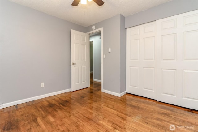 17123 6th Avenue Ct E, Spanaway, WA 98387 - unfurnished bedroom featuring wood finished floors, baseboards, a closet, a ceiling fan, and a textured ceiling
