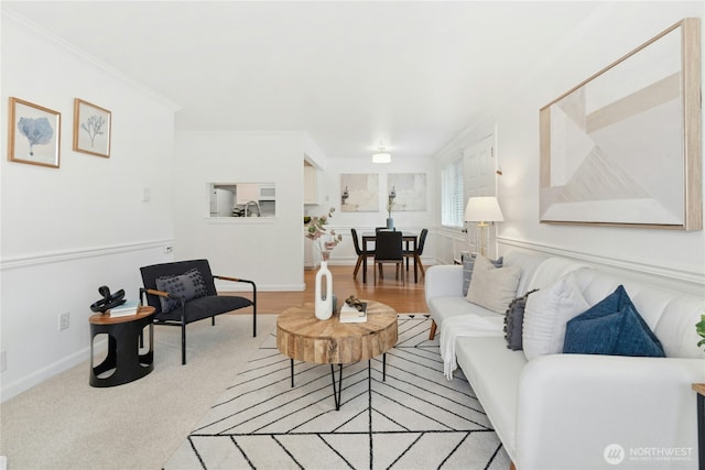 living area with light carpet, crown molding, and baseboards