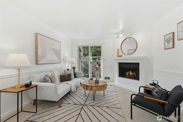 living room with visible vents, carpet, a brick fireplace, and crown molding