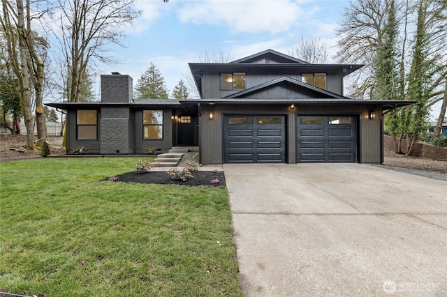 view of front of home with a garage, driveway, a front lawn, and a chimney