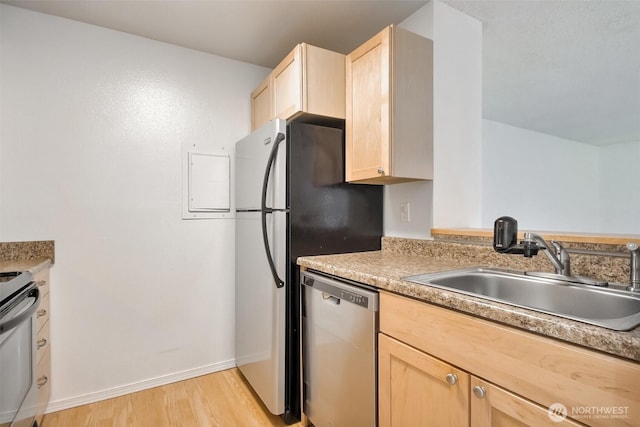 kitchen with a sink, light countertops, stainless steel dishwasher, and light brown cabinetry