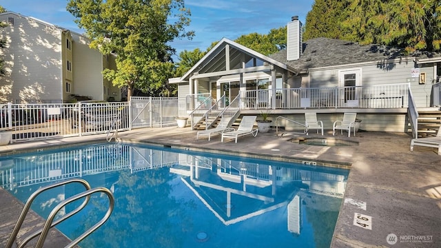 community pool with a patio area, stairs, fence, and a deck