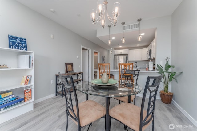 dining room featuring an inviting chandelier, light wood-style flooring, visible vents, and baseboards