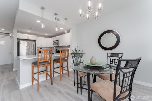 dining area featuring light wood-style floors, baseboards, visible vents, and recessed lighting