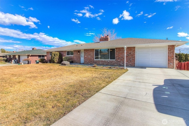 single story home with brick siding, a chimney, concrete driveway, a front yard, and a garage