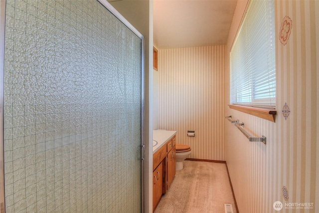 bathroom with visible vents, vanity, a shower stall, and toilet