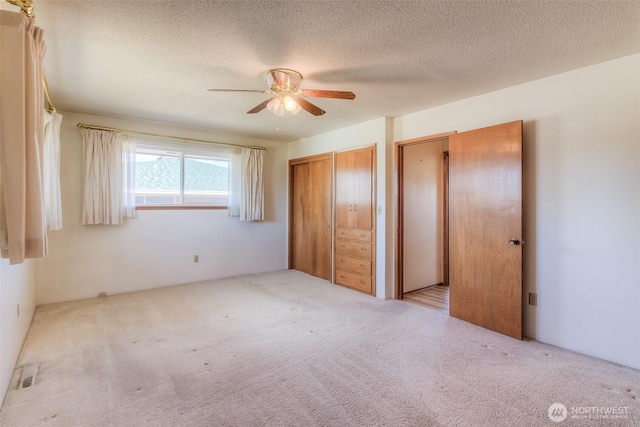 unfurnished bedroom featuring a textured ceiling, carpet, and a ceiling fan