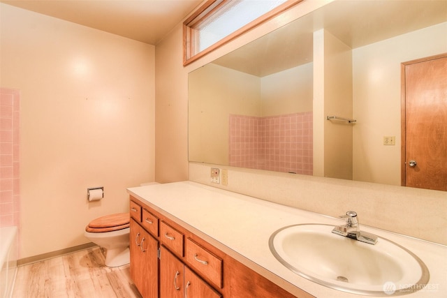 full bath with a washtub, wood finished floors, vanity, and toilet