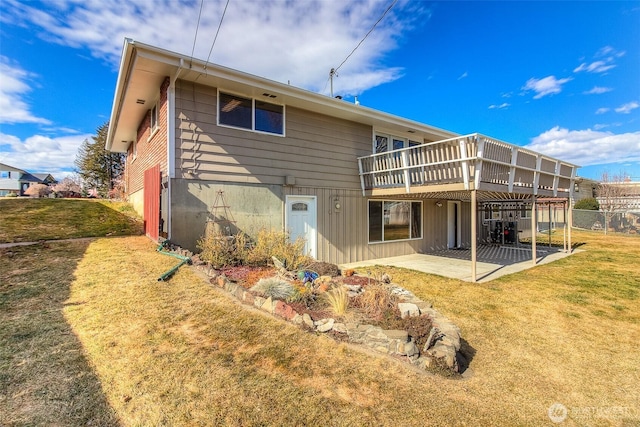 back of house with a deck, a yard, and a patio