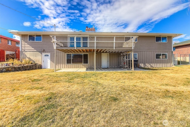 rear view of property featuring a patio, a yard, and board and batten siding