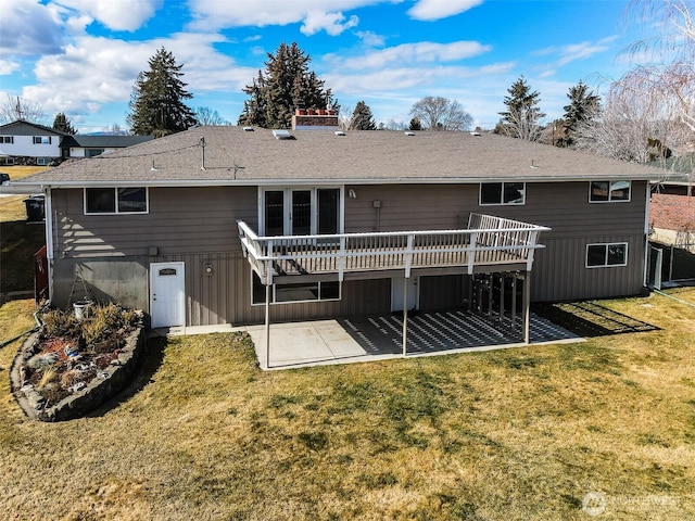 rear view of property featuring a patio area, a lawn, and a wooden deck