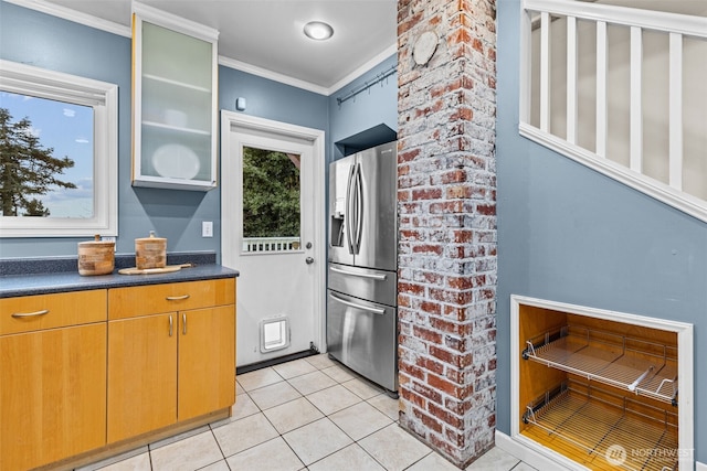 kitchen featuring light tile patterned flooring, plenty of natural light, glass insert cabinets, and stainless steel fridge with ice dispenser