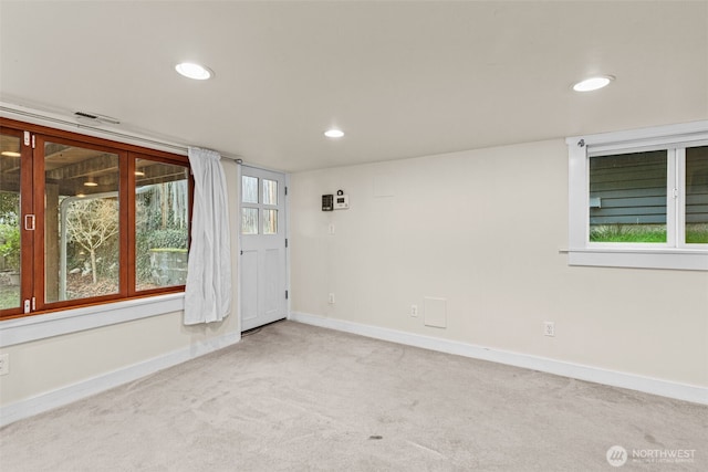 spare room with recessed lighting, light colored carpet, visible vents, and baseboards