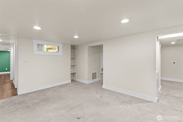 below grade area featuring recessed lighting, visible vents, and light colored carpet