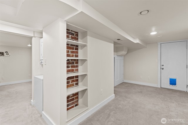 corridor featuring baseboards and light colored carpet