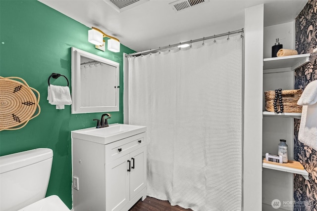 full bath featuring visible vents, vanity, toilet, and wood finished floors