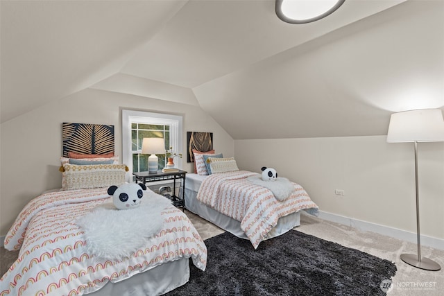 carpeted bedroom featuring lofted ceiling and baseboards