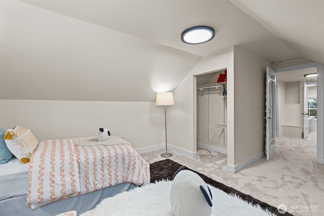 carpeted bedroom with baseboards, vaulted ceiling, and a closet