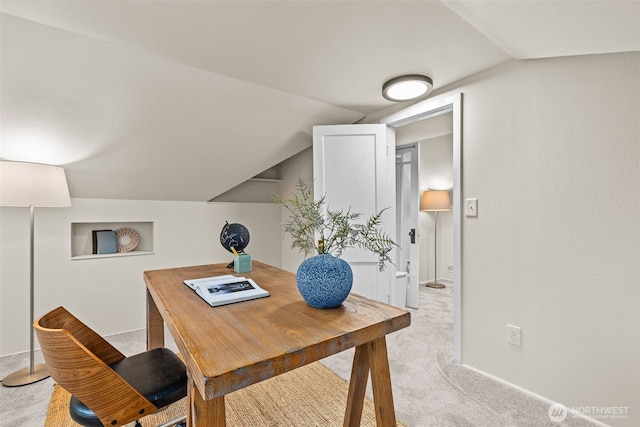 office space with lofted ceiling, baseboards, and light colored carpet