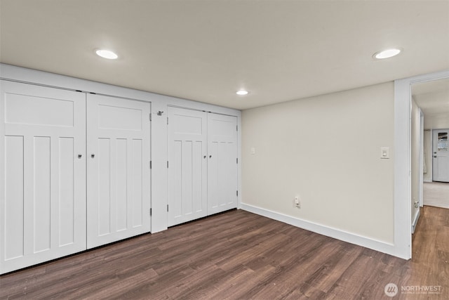 unfurnished bedroom featuring multiple closets, recessed lighting, dark wood-type flooring, and baseboards