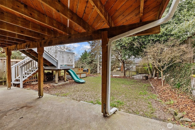 view of yard featuring a fenced backyard, a playground, and a patio