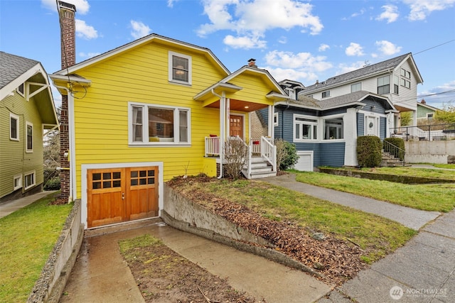 bungalow-style home with a garage, driveway, a chimney, and a front yard