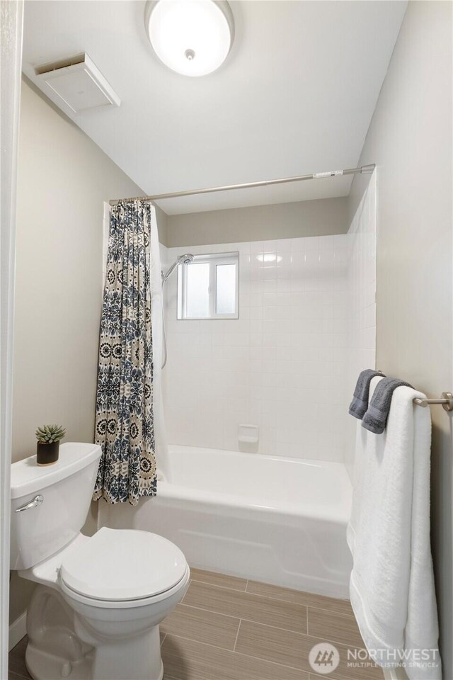 full bath with toilet and shower / tub combo with curtain