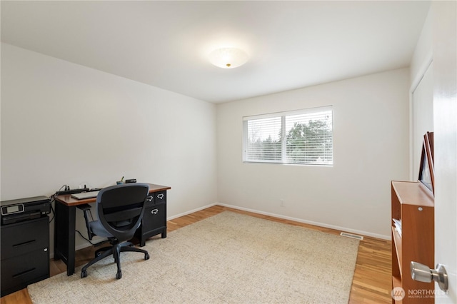 office area featuring visible vents, baseboards, and light wood-style floors