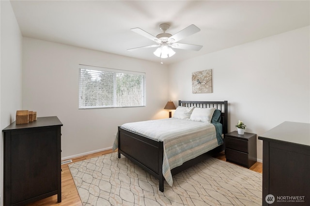 bedroom featuring ceiling fan, baseboards, and wood finished floors