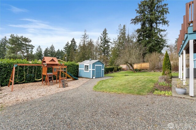 view of yard with a storage shed, an outdoor structure, and a playground