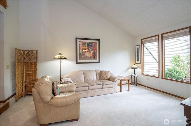 living room with high vaulted ceiling, light carpet, and baseboards