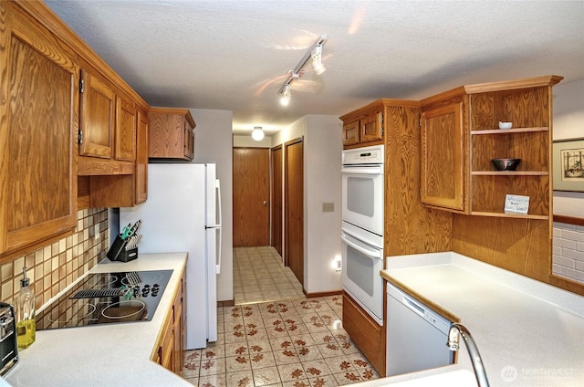 kitchen featuring light countertops, white appliances, and brown cabinetry