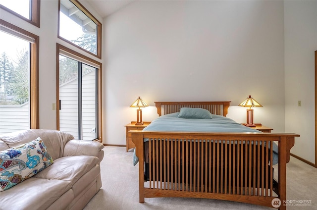 bedroom with light carpet, baseboards, a towering ceiling, and access to exterior