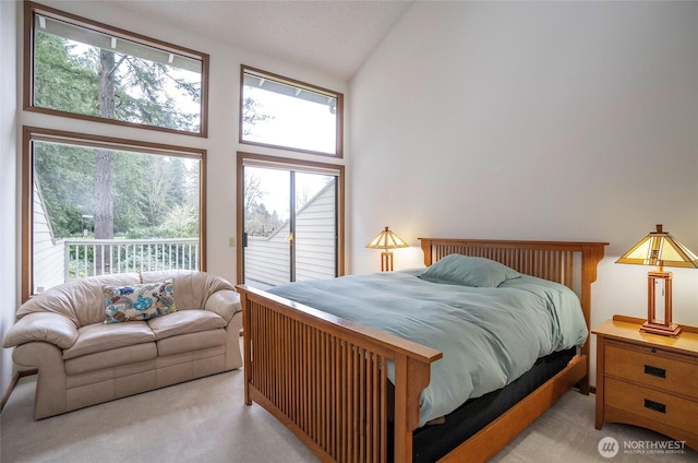 carpeted bedroom with access to outside and high vaulted ceiling