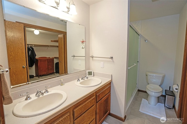 full bath with a stall shower, a sink, toilet, and tile patterned floors