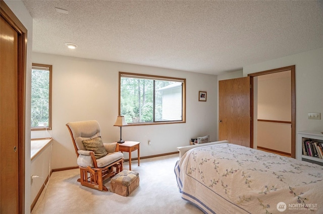 bedroom featuring a textured ceiling, baseboards, and carpet flooring