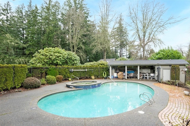 view of pool with a patio area, fence, and a pool with connected hot tub