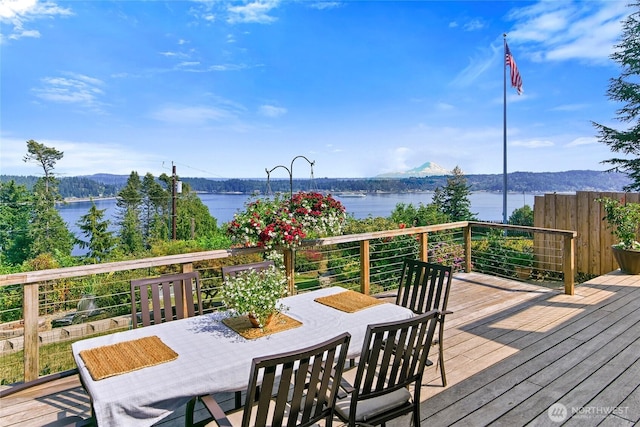 wooden deck featuring outdoor dining area and a water and mountain view