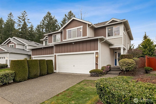 view of front facade with driveway, an attached garage, and fence