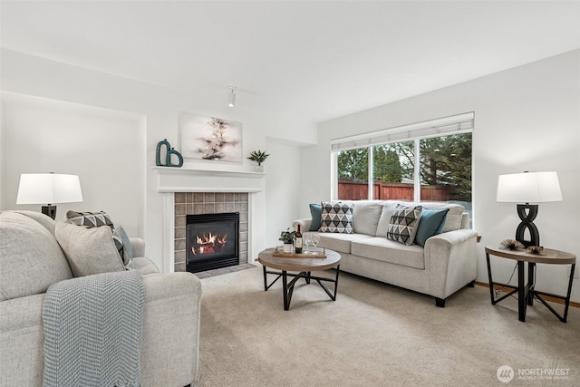 living room featuring a tile fireplace and light colored carpet