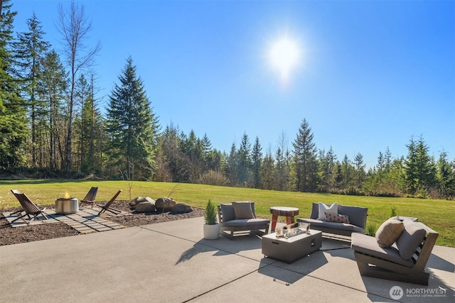 view of patio featuring a forest view and an outdoor living space with a fire pit