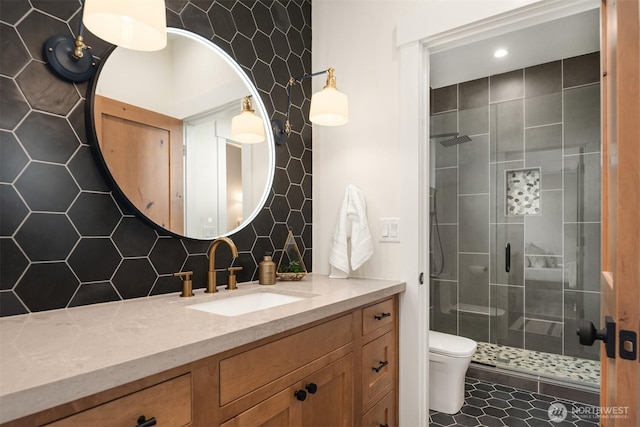 bathroom featuring toilet, backsplash, a shower stall, and vanity