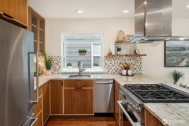 kitchen with stainless steel appliances, brown cabinets, island exhaust hood, and a sink